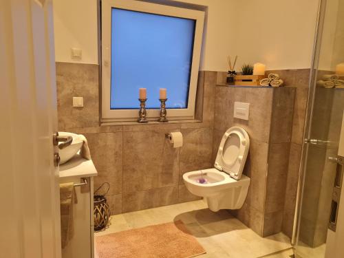 a bathroom with a toilet and a window at Penthaus in Soltau