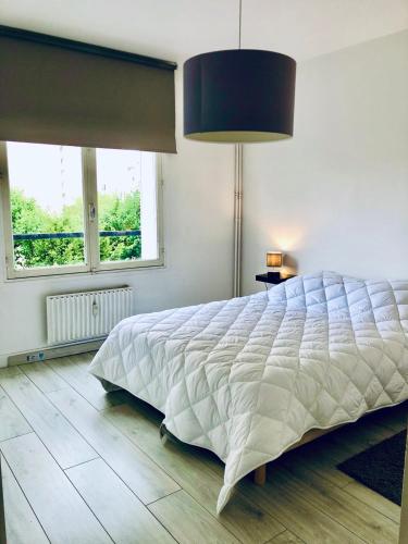 une chambre avec un grand lit et deux fenêtres dans l'établissement Valentin in Caen, à Caen