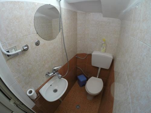 a bathroom with a toilet and a sink and a mirror at Hotel Ideal in Shkodër