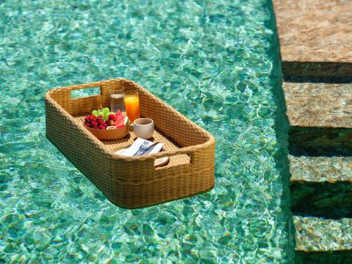 einen Picknickkorb mit Obst und eine Kerze im Pool in der Unterkunft Patmosphere Luxury Escape Adults-Only in Patmos
