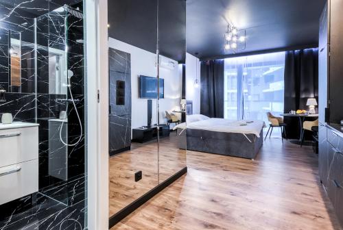 a bedroom with a bed and a bathroom with a shower at Wola Luxury Stay in Warsaw