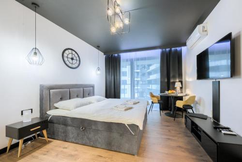 a bedroom with a bed and a desk and a dining room at Wola Luxury Stay in Warsaw
