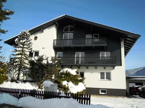 a black and white building with a balcony at Pension Ferienwohnung Pirhofer in Kramsach