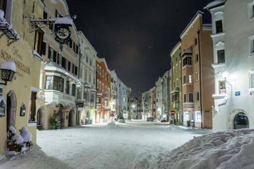 a snow covered street at night with buildings at Pension Ferienwohnung Pirhofer in Kramsach