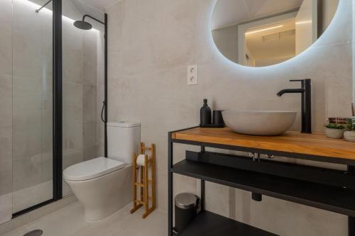 een badkamer met een wastafel, een toilet en een spiegel bij Madera Negra in Córdoba