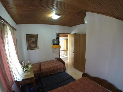 Habitación con cama, ventana y TV. en Hotel Ideal, en Shkodër