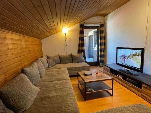 a living room with a couch and a television at Apartment Drexler by Interhome in Arrach