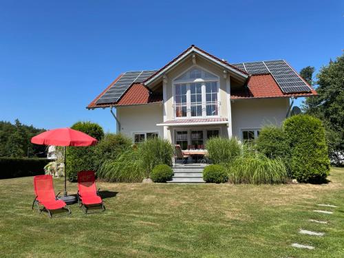 Schorndorf的住宿－Holiday Home Ederer by Interhome，两把椅子和一把伞在房子前面