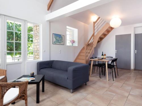 ein Wohnzimmer mit einem blauen Sofa und einem Tisch in der Unterkunft Holiday Home De Malau - MPY400 by Interhome in Le Mesnil-Patry