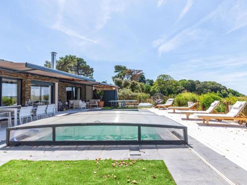 a swimming pool with chairs and a house at Holiday Home Indigo-Vue Mer et Piscine chauffée by Interhome in Saint-Brevin-les-Pins