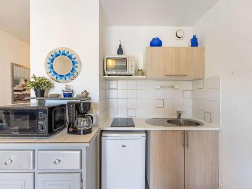 a kitchen with a sink and a microwave at Apartment Les Roches Bleues-1 by Interhome in Collioure