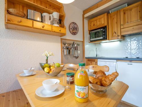 a kitchen with a table with a bottle of orange juice at Apartment Arcelle-20 by Interhome in Val Thorens