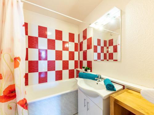 La salle de bains est pourvue d'un mur en damier rouge et blanc. dans l'établissement Apartment Vostok Zodiaque-57 by Interhome, au Corbier