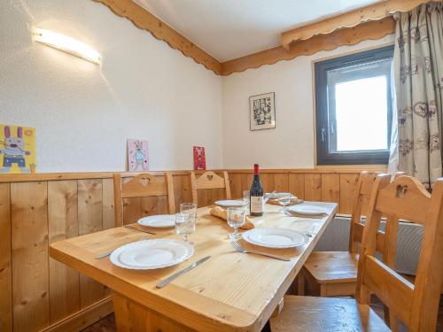 - une table en bois avec des assiettes et une bouteille de vin dans l'établissement Apartment Vanoise 751 by Interhome, à Val Thorens