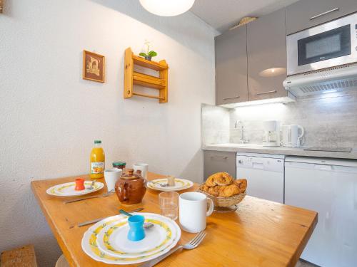 une cuisine avec une table en bois et des plaques de cuisson. dans l'établissement Studio vanoise 578 by Interhome, à Val Thorens