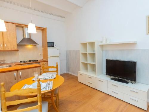 uma cozinha e uma sala de jantar com uma mesa e uma televisão em Apartment Gracia Torrijos by Interhome em Barcelona