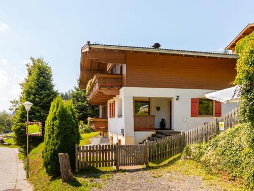 a house with a wooden fence in front of it at Holiday Home Haus am Sonnenhang by Interhome in Spielbichl