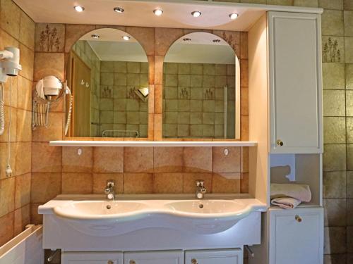 a bathroom with a sink and two mirrors at Apartment Erika by Interhome in Kappl