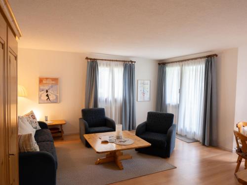 un soggiorno con 2 sedie e un tavolo di Apartment Chesa Zupeda C2 by Interhome a Surlej