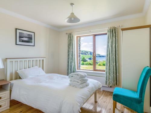 a bedroom with a bed and a chair and a window at Holiday Home Cuascrome by Interhome in Cahersiveen