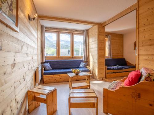 - un salon avec un canapé bleu et une fenêtre dans l'établissement Apartment Arcelle-10 by Interhome, à Val Thorens