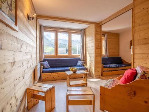 een woonkamer met een blauwe bank en een raam bij Apartment Arcelle-10 by Interhome in Val Thorens