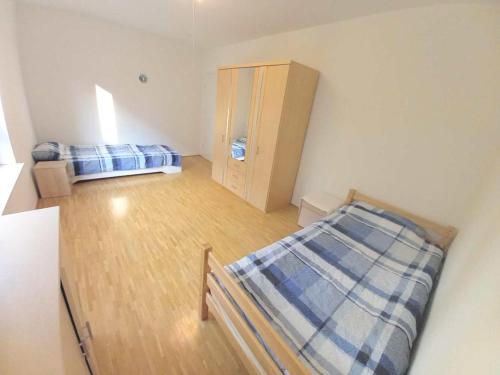 Cette petite chambre comprend 2 lits et une armoire. dans l'établissement Spacious & Modern 4-Room-Flat *Garden and WiFi*, à Ostfildern