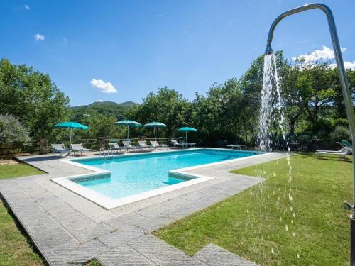 a swimming pool with a water fountain at Holiday Home La Badia by Interhome in Dicomano