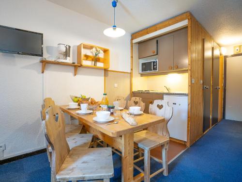 une cuisine avec une table et des chaises en bois dans l'établissement Apartment Arcelle 111 by Interhome, à Val Thorens