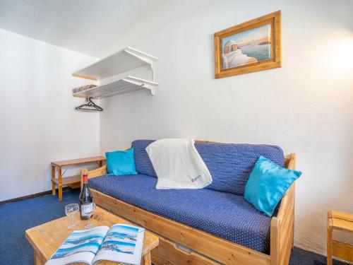 un salon avec un canapé bleu et une table dans l'établissement Apartment Arcelle 111 by Interhome, à Val Thorens