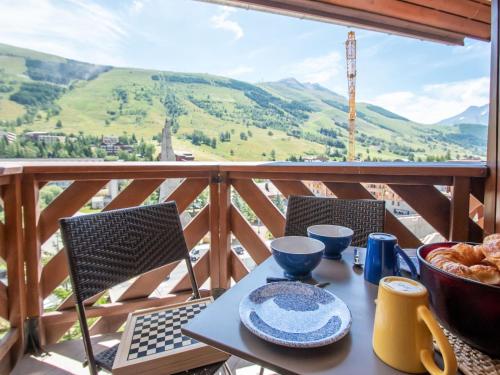 a table with a plate of food on a balcony at Apartment La Grande Chaume by Interhome in Les Deux Alpes