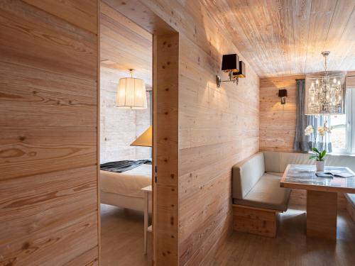 Zimmer mit Holzwänden, einem Bett und einem Tisch in der Unterkunft Apartment Chesa Sur Val 21 by Interhome in St. Moritz