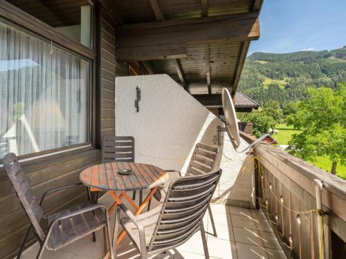 einen Tisch und Stühle auf dem Balkon eines Hauses in der Unterkunft Apartment Haus Point by Interhome in Maishofen