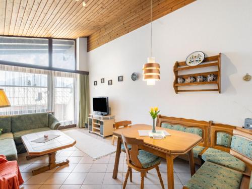 a living room with a table and a couch at Apartment Haus Point by Interhome in Maishofen