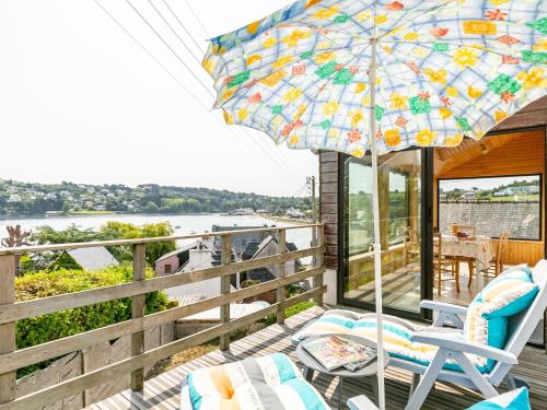 a patio with chairs and an umbrella on a deck at Holiday Home Ti an Aod by Interhome in Plougasnou