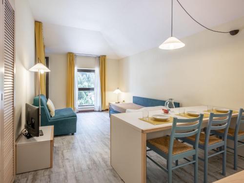 eine Küche und ein Wohnzimmer mit einem Tisch und Stühlen in der Unterkunft Apartment Universo-4 by Interhome in Pré-Saint-Didier