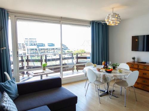 un salon avec une table et une grande fenêtre dans l'établissement Apartment Les Marinas-3 by Interhome, à Deauville