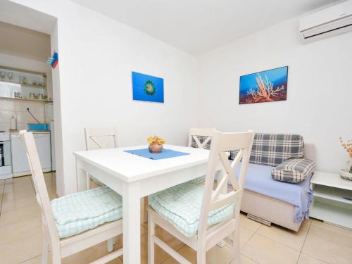 eine Küche und ein Esszimmer mit einem weißen Tisch und Stühlen in der Unterkunft Apartment Renata by Interhome in Barić Draga