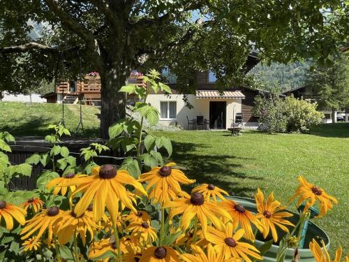 a bunch of yellow flowers in front of a house at Apartment Sweda by Interhome in Fieschertal