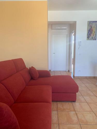 a living room with a red couch and a door at Nova Lux in Custonaci