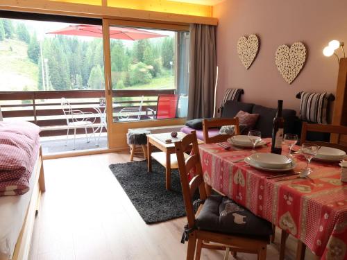 une salle à manger avec une table et une vue sur un balcon dans l'établissement Studio Rosablanche D13 by Interhome, à Siviez