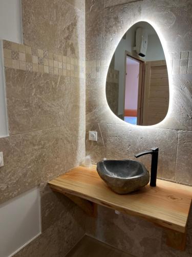 bagno con lavandino nero e specchio di LE DOMAINE DES CYGNES a Lamballe