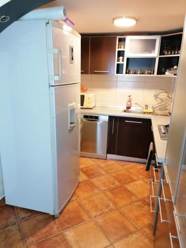 a kitchen with a refrigerator and a tile floor at Lotus in Arefu