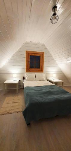 a bedroom with a large bed and two tables at Ośrodek Edward in Mikoszewo
