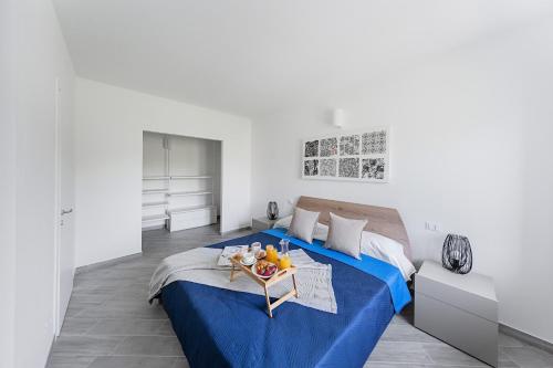 una camera con letto blu e vassoio di frutta di San Carlo Borromeo Apartments by Wonderful Italy a Soiano del Lago