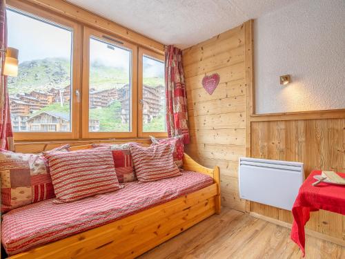 1 dormitorio con cama con almohadas y ventana en Apartment Arcelle-22 by Interhome, en Val Thorens