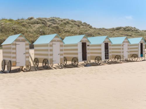 a row of beach huts on a sandy beach at Apartment Sea Breeze by Interhome in Bredene
