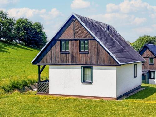 a house with a wooden roof on a green field at Holiday Home Holiday Hill 42 by Interhome in Lauterwasser