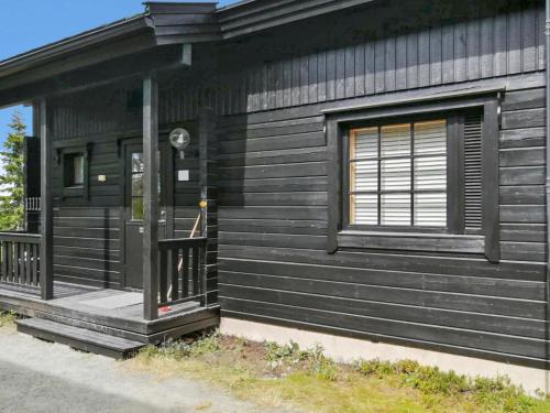 een zwart huis met een veranda en een raam bij Holiday Home Rukan komia chalet by Interhome in Ruka