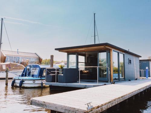 a small boat is docked at a dock at Holiday Home De Meerparel-1 by Interhome in Uitgeest